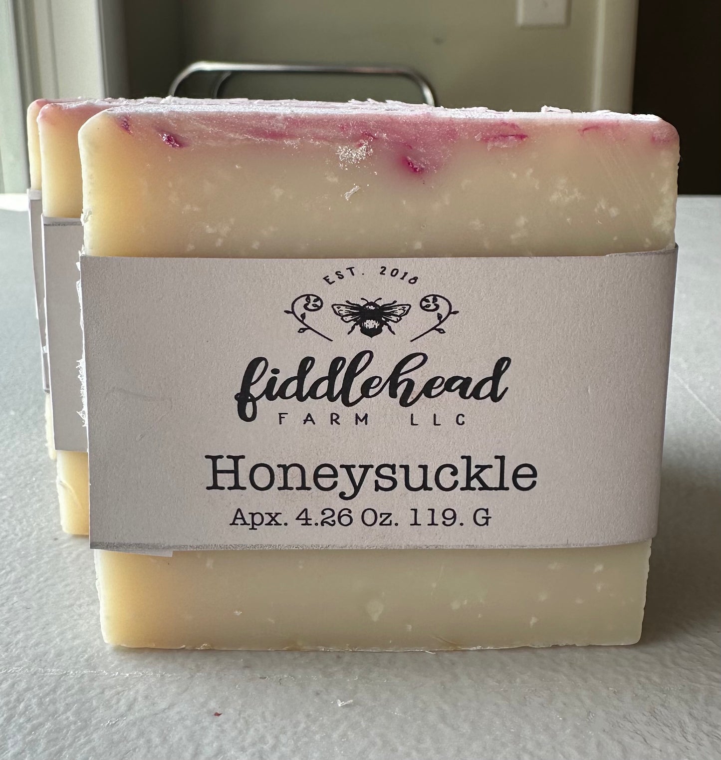 Bar of soap with 'fiddlehead farm LLC' label on a white surface